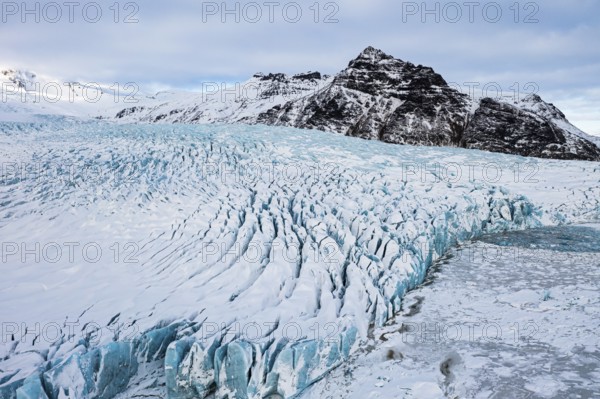 Snow-covered icebergs in the Fjallsarlon glacier lagoon, with the Öraefajökull glacier behind,