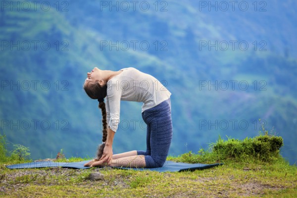 Yoga, outdoors young beautiful slender woman yoga instructor doing camel pose Ustrasana asana