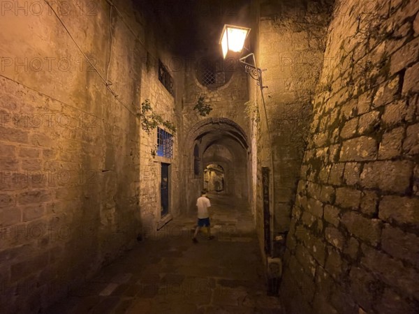 Boy in an alley in the old town of Kotor, historical, night, eerie, Bay of Kotor, Adriatic Sea,