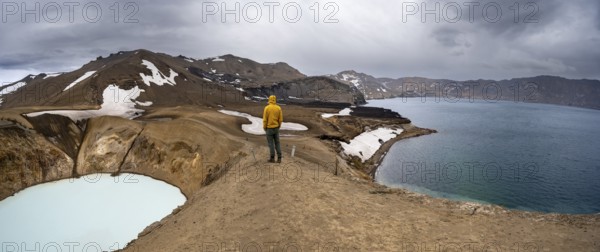 Tourist at the crater rim, crater lake Víti and Öskjuvatn in the crater of Askja volcano, volcanic