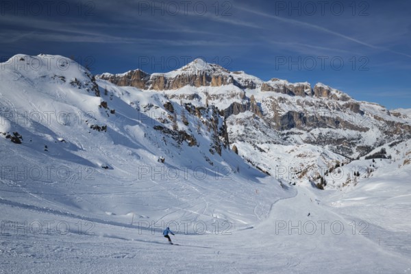 View of a ski resort piste with people skiing in Dolomites in Italy. Ski area Arabba. Arabba,