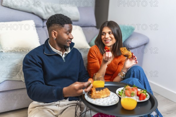 Couple sharing a cozy breakfast at home, enjoying fresh fruit, pastries, and juice, creating a warm