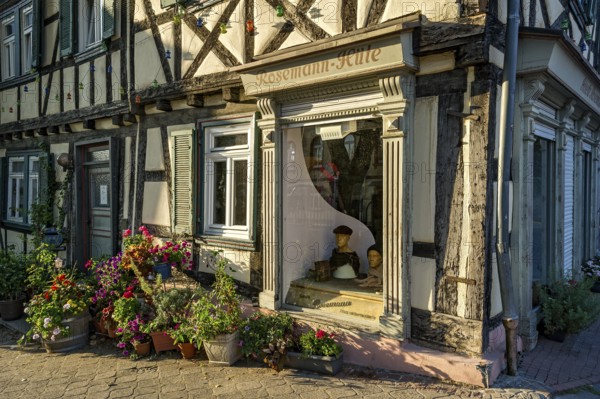 Idyllic old half-timbered house with floral decorations and shop window of milliner, milliner, hat