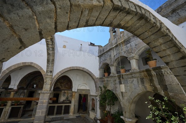 Historic courtyard with stone arches and white walls in a Mediterranean atmosphere, Agiou Theologou