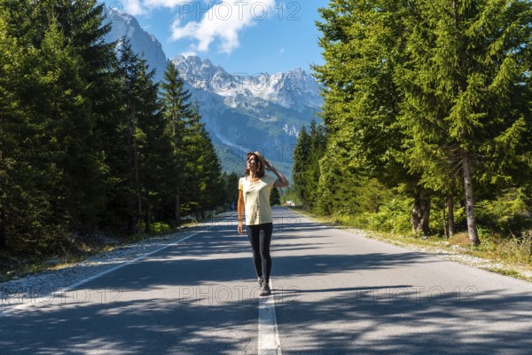 Young tourist walking on the road in Valbona valley, Theth national park, Albanian Alps, Valbona