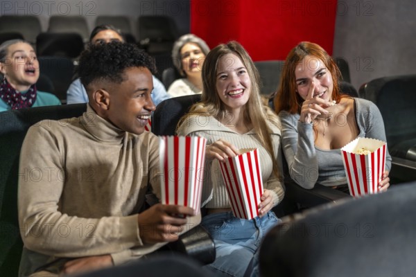Young people enjoying a movie at the cinema, sharing laughter and popcorn, creating memorable
