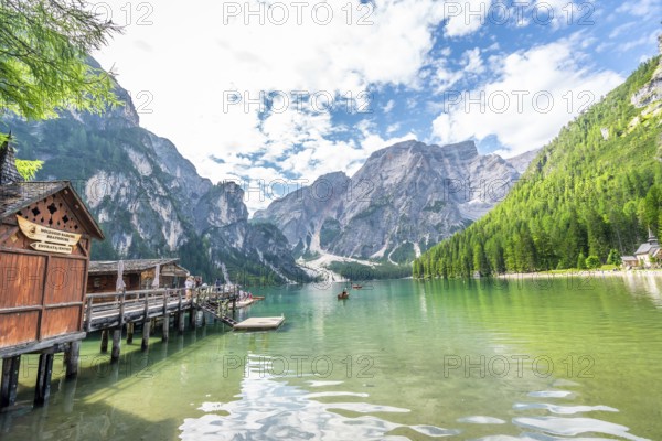 Tourists kayaking on the serene emerald waters of lake braies, surrounded by the breathtaking