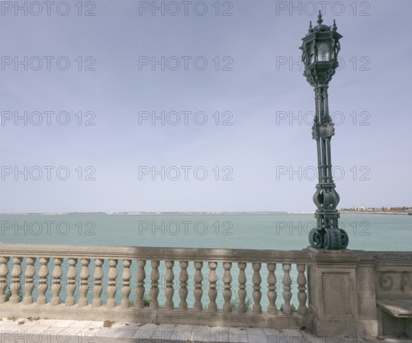 View over the bay of Cadiz with lamppost from the garden Jardines Clara Campoamor, Cádiz, Spain,
