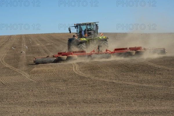 Tractor with rollers preparing the ground for spring sowing at Krageholm, Ystad Municipality, Skåne