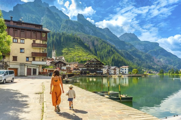 Tourists strolling along the lakefront of alleghe, a charming village nestled in the heart of the