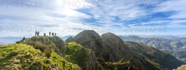 Group of hikers enjoying stunning views from the peak of aiako harria mountain in oiartzun,