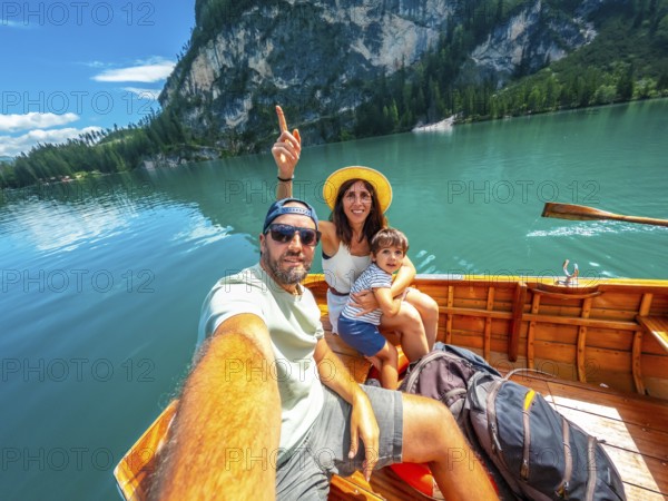 Family taking a selfie while enjoying a boat trip on the beautiful lake braies, surrounded by the