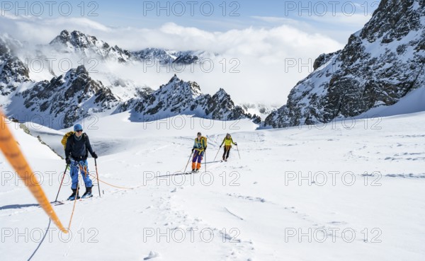 Ski tourer with rope, rope team on the Vadret da Porchabella glacier on the ascent to the summit of