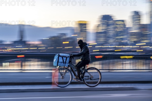 Skyline of the city centre of Frankfurt am Main, cyclist on the Flößerbrücke, Wolt delivery