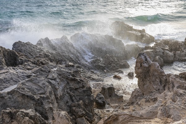 Sea water lashes over the eroded rocks on Salines beach, Ibiza, Balearic Islands, Mediterranean