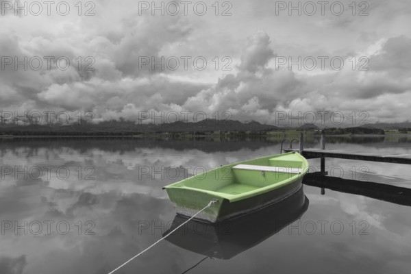Storm clouds at sunset, a green rowing boat lashed to the wooden jetty, Hopfensee, Hopfen am See,