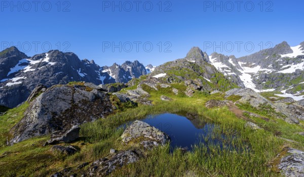 Small pond in moor landscape at Trollfjord Hytta, mountain landscape with rocky mountain peaks, at