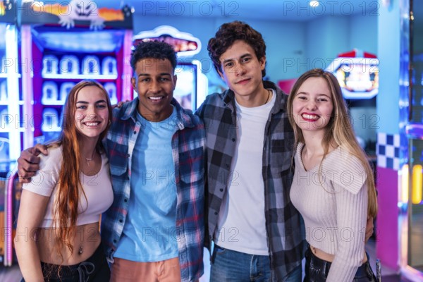 Four young multiethnic friends embrace, enjoying their weekend together at a vibrant bowling alley