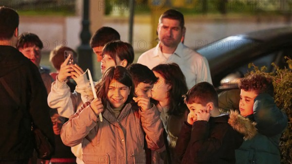 A group of children laughing and covering their ears, fireworks, Easter fire Psinthos, Holy