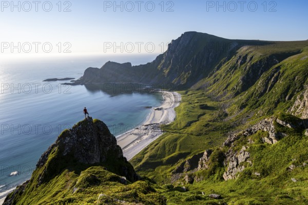 Climber on a rock, view of picturesque coastal landscape, steep coast with peak Måtind or Måtinden,