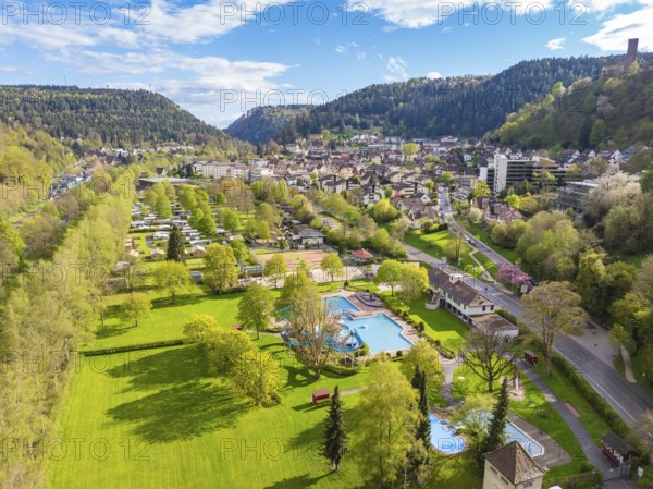 Green parkland with pool and town in a mountainous setting, Bad Liebenzell, Calw district, Black