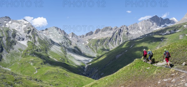 Three mountaineers on a hiking trail on the Daberlenke, view of rocky mountain peaks in the