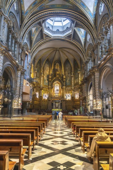 Tourists admiring the interior of santa maria de montserrat basilica, located in the montserrat