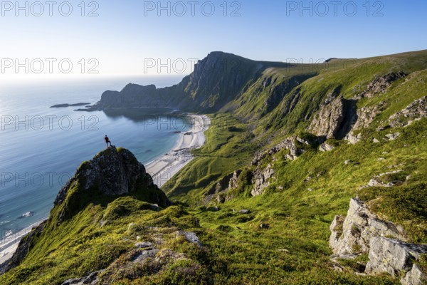Climber on a rock, view of picturesque coastal landscape, steep coast with peak Måtind or Måtinden,