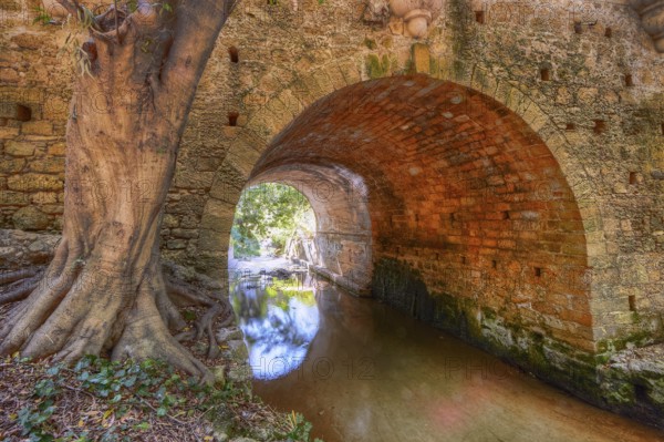 Stone tunnel with tree and quiet river, pure nature, Rodini Park, municipal park, Rhodes Town,