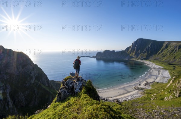 Mountaineer with view of coastal landscape, steep coast with summit Måtind or Måtinden, Høyvika