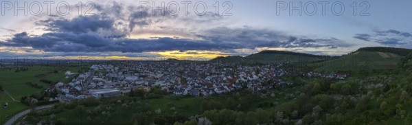 Urban panorama at dusk with dense clouds and rolling hills in the distance, Korb-Steinreinach, Rems