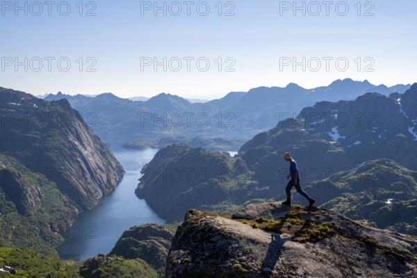 Mountaineer, young man in front of mountain landscape, fjord Trollfjord and mountains, hike to