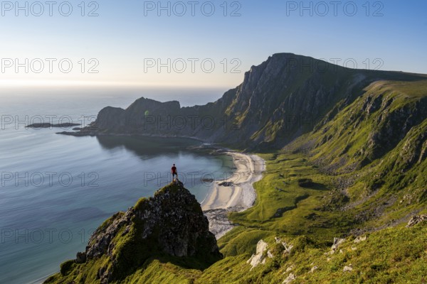 Climber on a rock, view of picturesque coastal landscape, steep coast with peak Måtind or Måtinden,