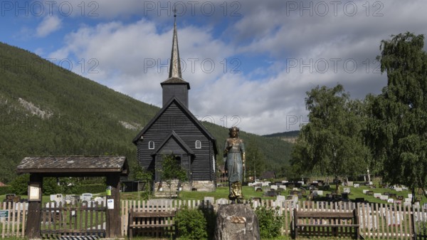 Wooden church in Sel with a cemetery and a statue of Kristian Lavranstochter, the main character