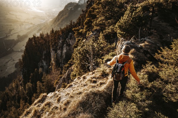 Hiker in the Allgäu at sunset in spring on the Zirmgrat near Pronten in the Allgäu