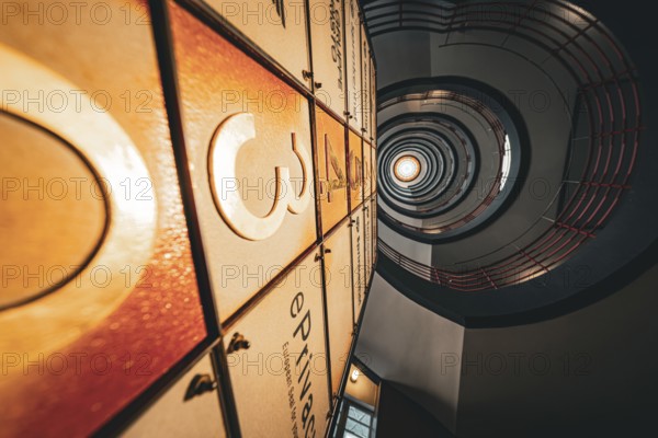 Dramatic view upwards through a spiral staircase with warm light, SPRINKENHOF, Hamburg, Germany,