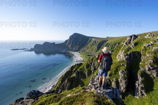 Mountaineer in front of view of coastal landscape, steep coast with summit Måtind or Måtinden,