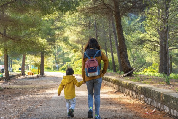 Mother and son enjoying a peaceful walk through the natural beauty of la fontcalda, a sanctuary