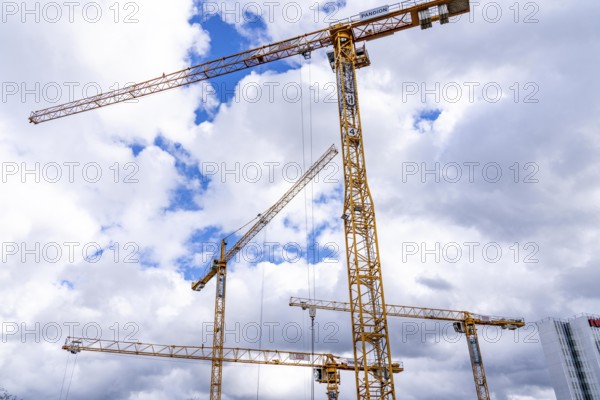 Construction cranes, on a large construction site in Düsseldorf, construction of condominium in the