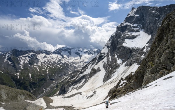 Mountaineer hiking in a snowfield, Nördliche Mörchnerscharte, behind mountain peak Kleiner Mörchner