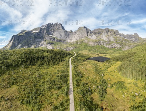Panoramic aerial view of road in mountain scenery, passing lakes and meadows, road from E10 to