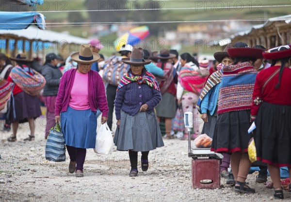 Peruvian woman with traditional skirts and hats at the indigenous market in Chinchero, Cusco