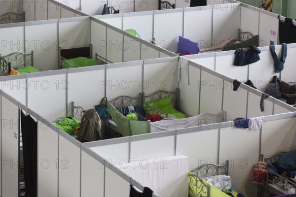 Temporary rooms with beds are set up in an emergency shelter for refugees on 9 December 2015 in a