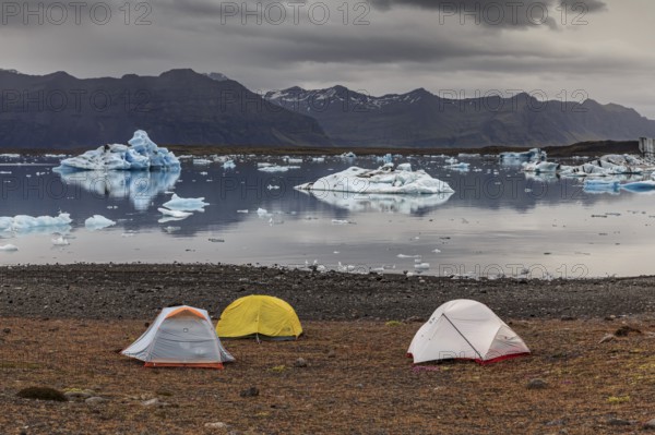 Tents in front of glacier lagoon, icebergs, camping, mountains, cloudy, winter, Jökulsarlon,