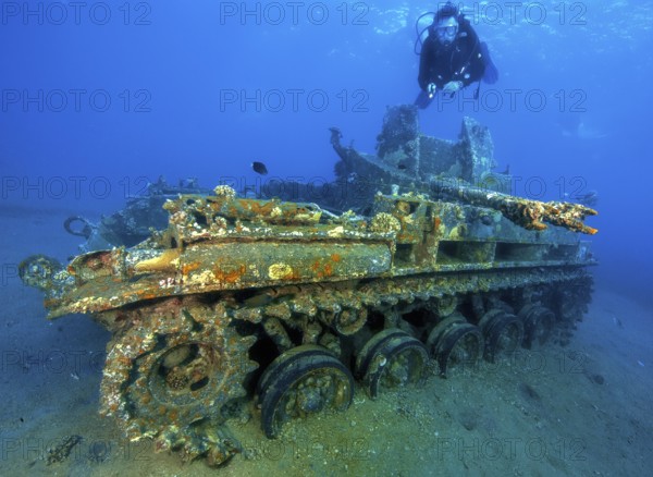Underwater photo of diver swimming above looking at as an attraction for underwater sportsmen
