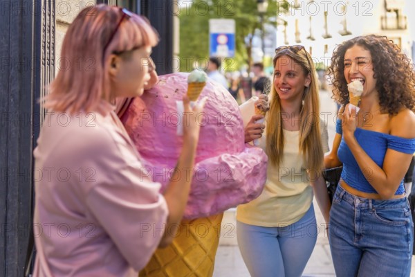 Girls having fun eating ice cream in the city standing in front of ice cream store with a giant