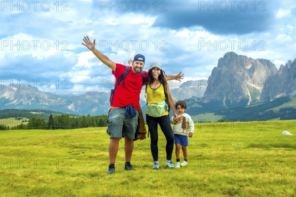 Happy family enjoying summer vacation in the italian alps, embracing the breathtaking scenery of