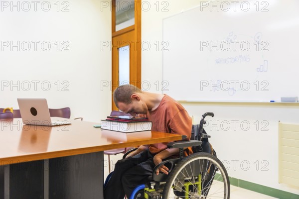 Side view horizontal photo with copy space of a man with cerebral palsy using digital tablet