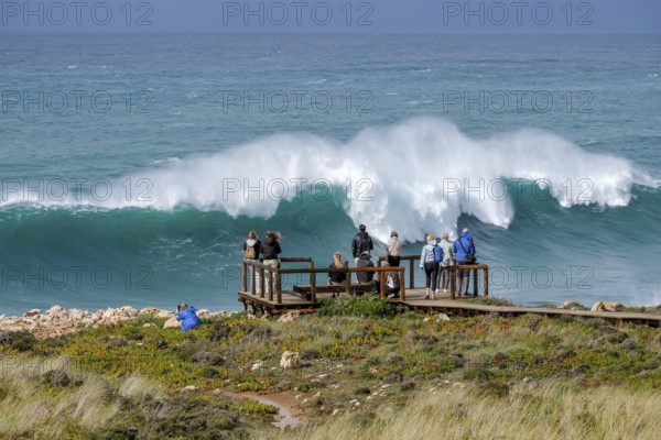 Carrapateira, Algarve, Portugal - Tourists on a viewing platform marvel at the roaring surf and