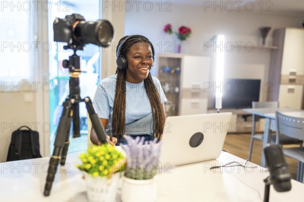 Young female content creator smiling and recording video with professional equipment in her living